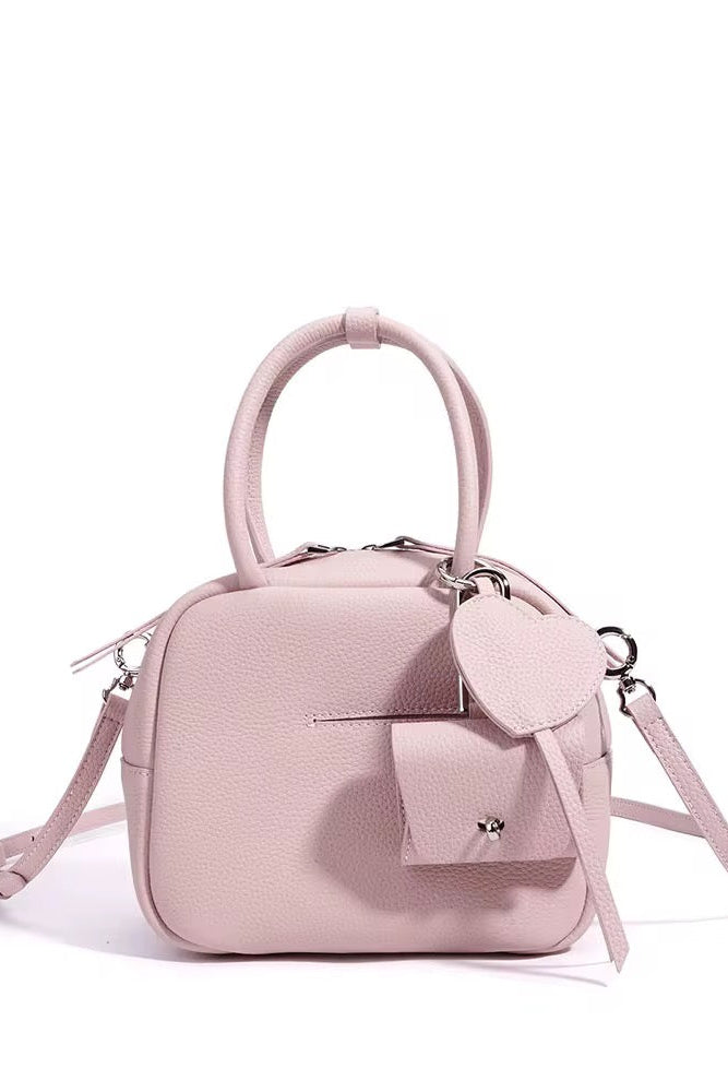 Pink handbag with a strap on a white background