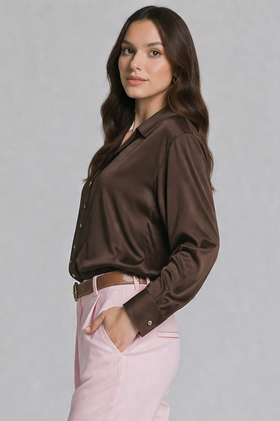 Woman wearing a brown blouse and pink pants on a gray background