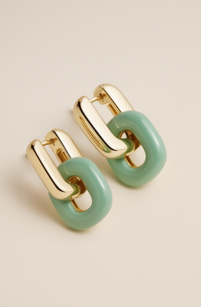 Pair of gold and green chain-link earrings on a beige background