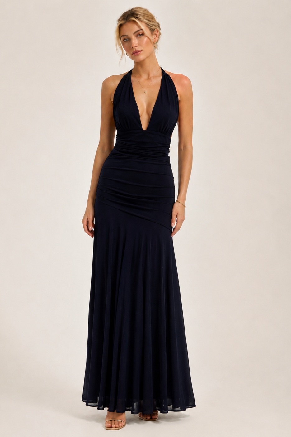 Woman wearing a black halter neck gown on a plain background