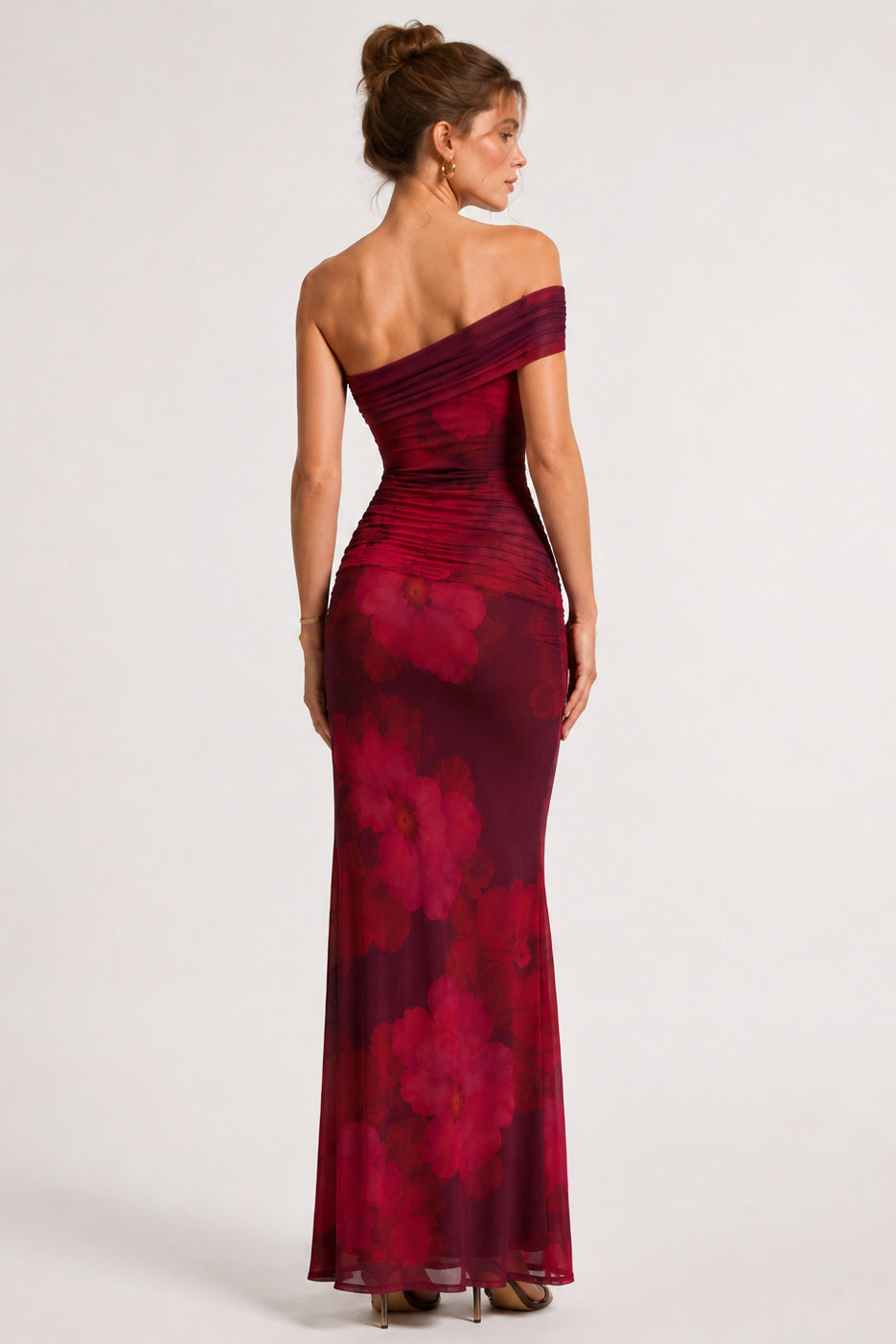 Woman wearing a burgundy one-shoulder dress on a white background