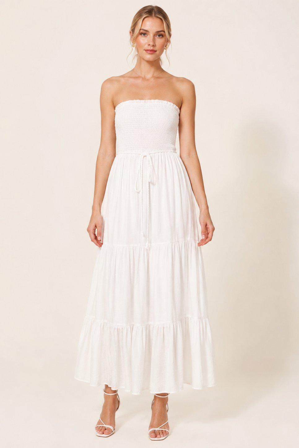 Woman wearing a strapless white dress on a plain background