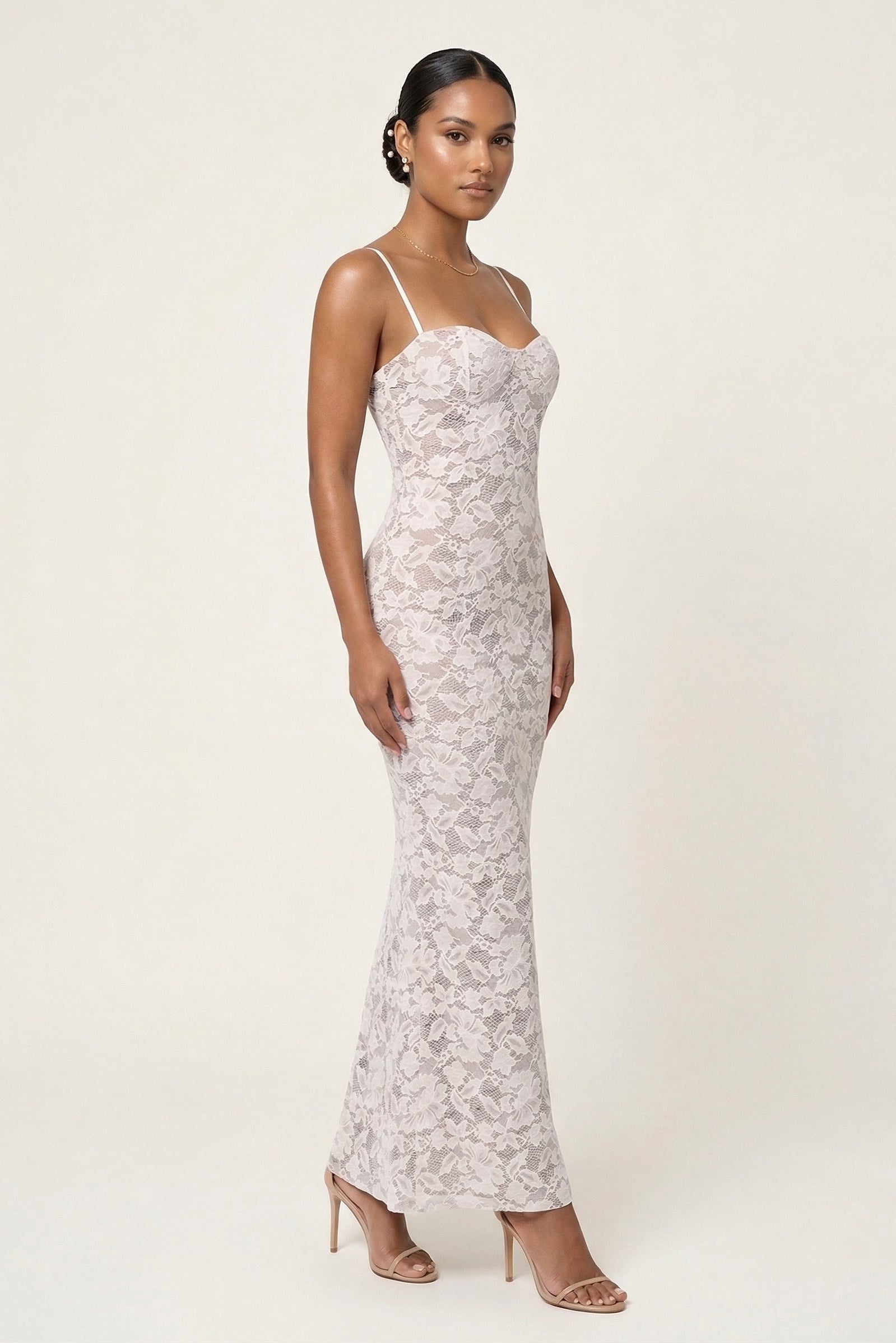 Woman wearing a white lace dress on a plain background