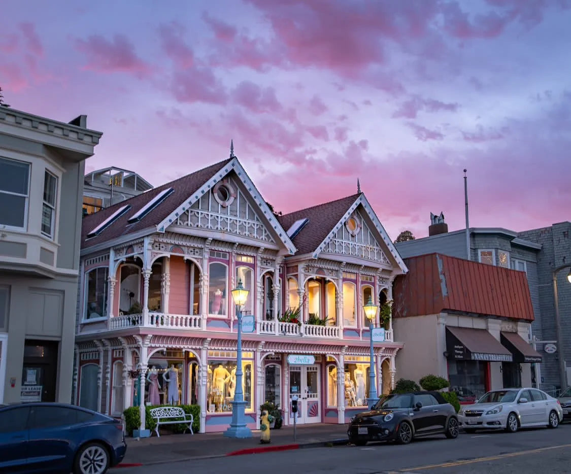 A photo of 2bella location in Sausalito: a victorian-style building with a pink sky at sunset