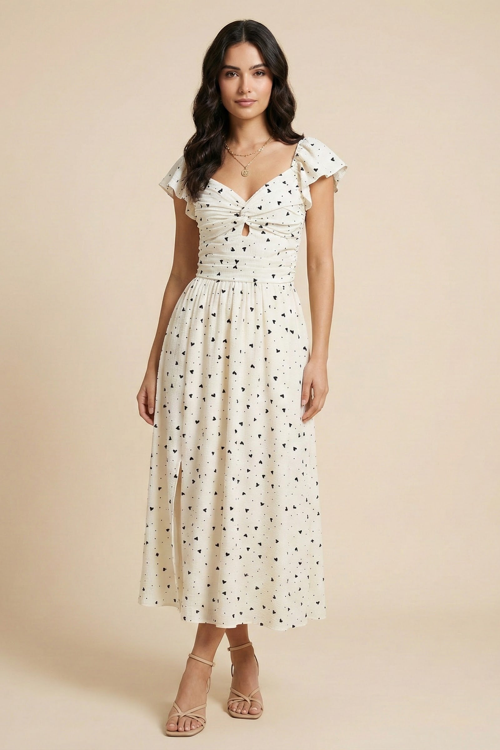 Woman wearing a white floral dress against a beige background