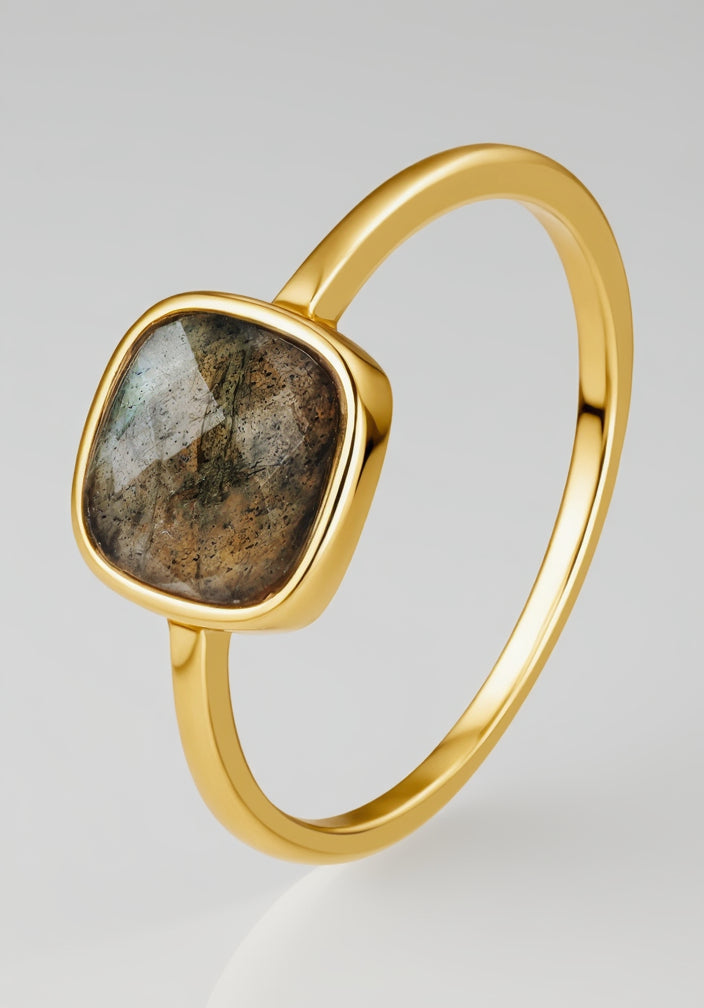 Gold ring with a labradorite stone on a white background