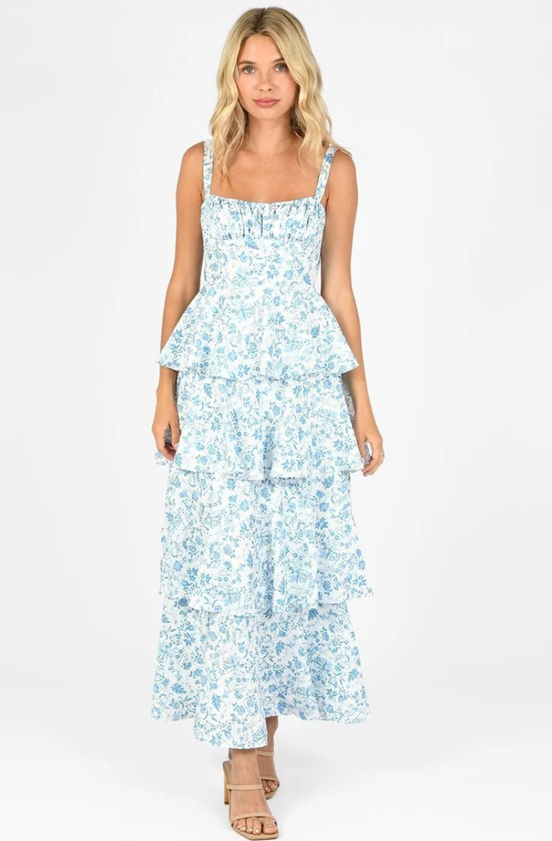 Woman wearing a tiered blue floral maxi dress with shoulder straps