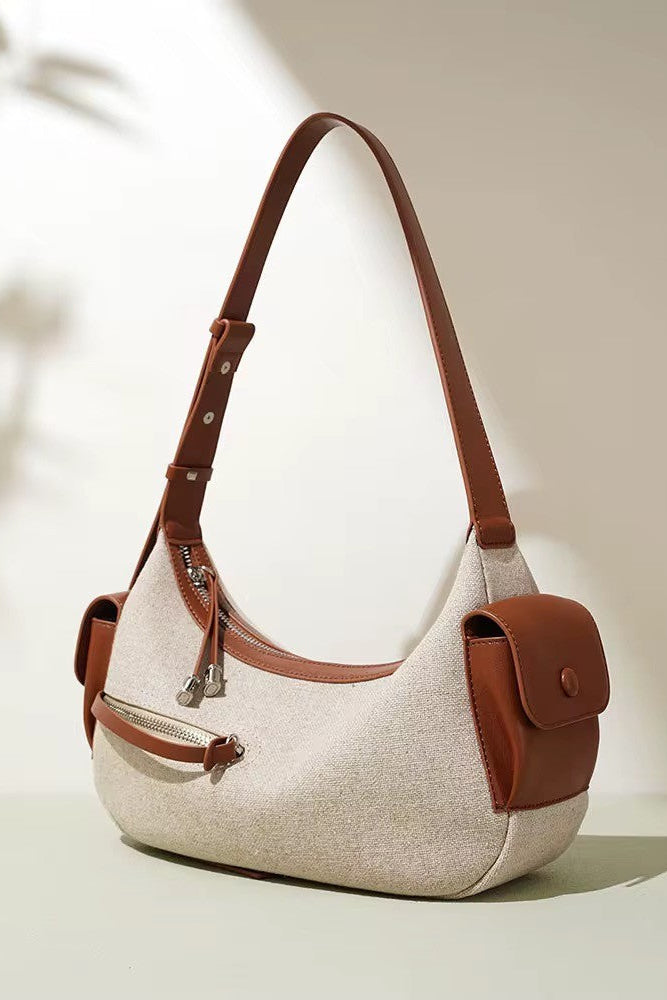 Beige handbag with brown leather accents on a light background