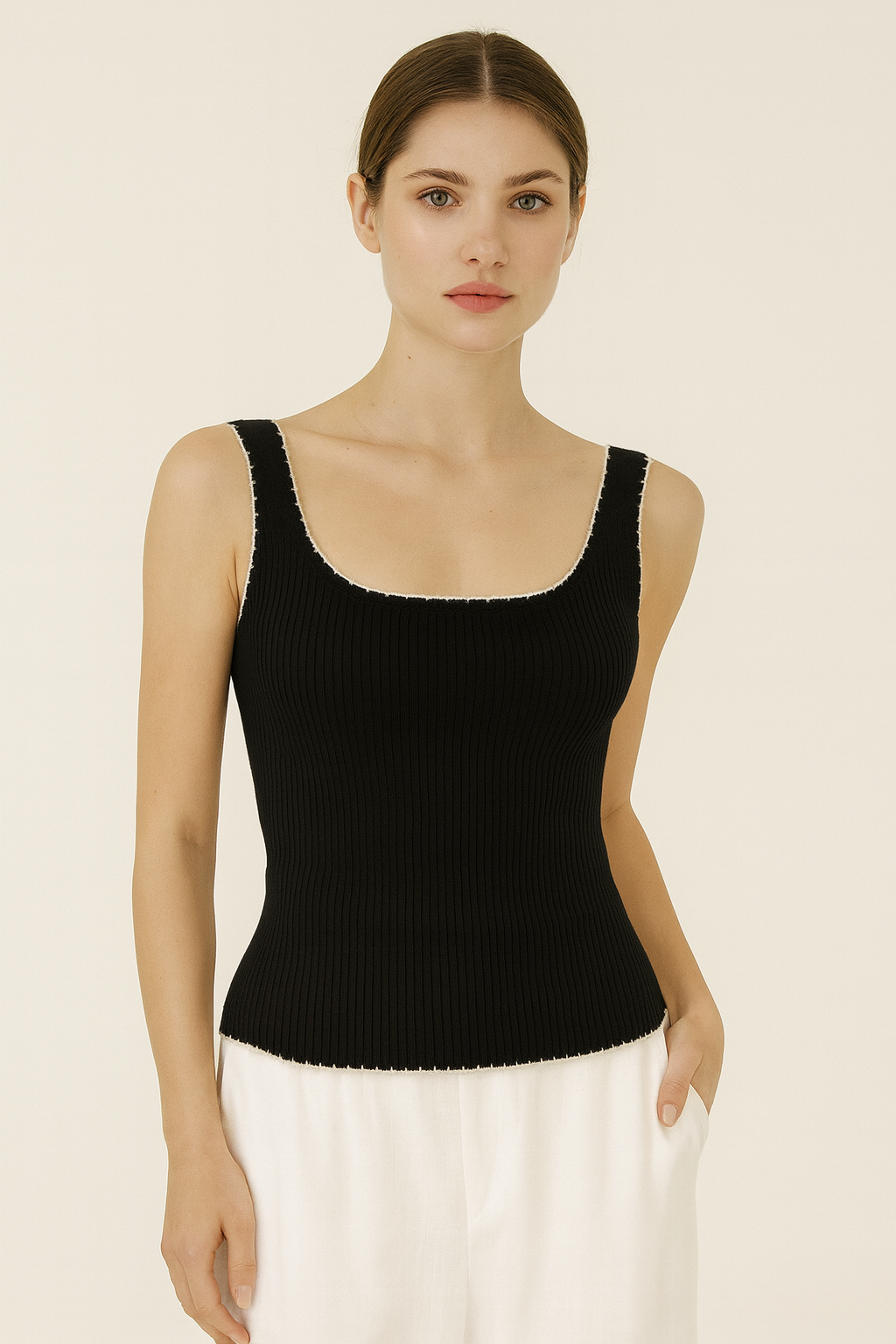 Woman wearing a black sleeveless top against a beige background