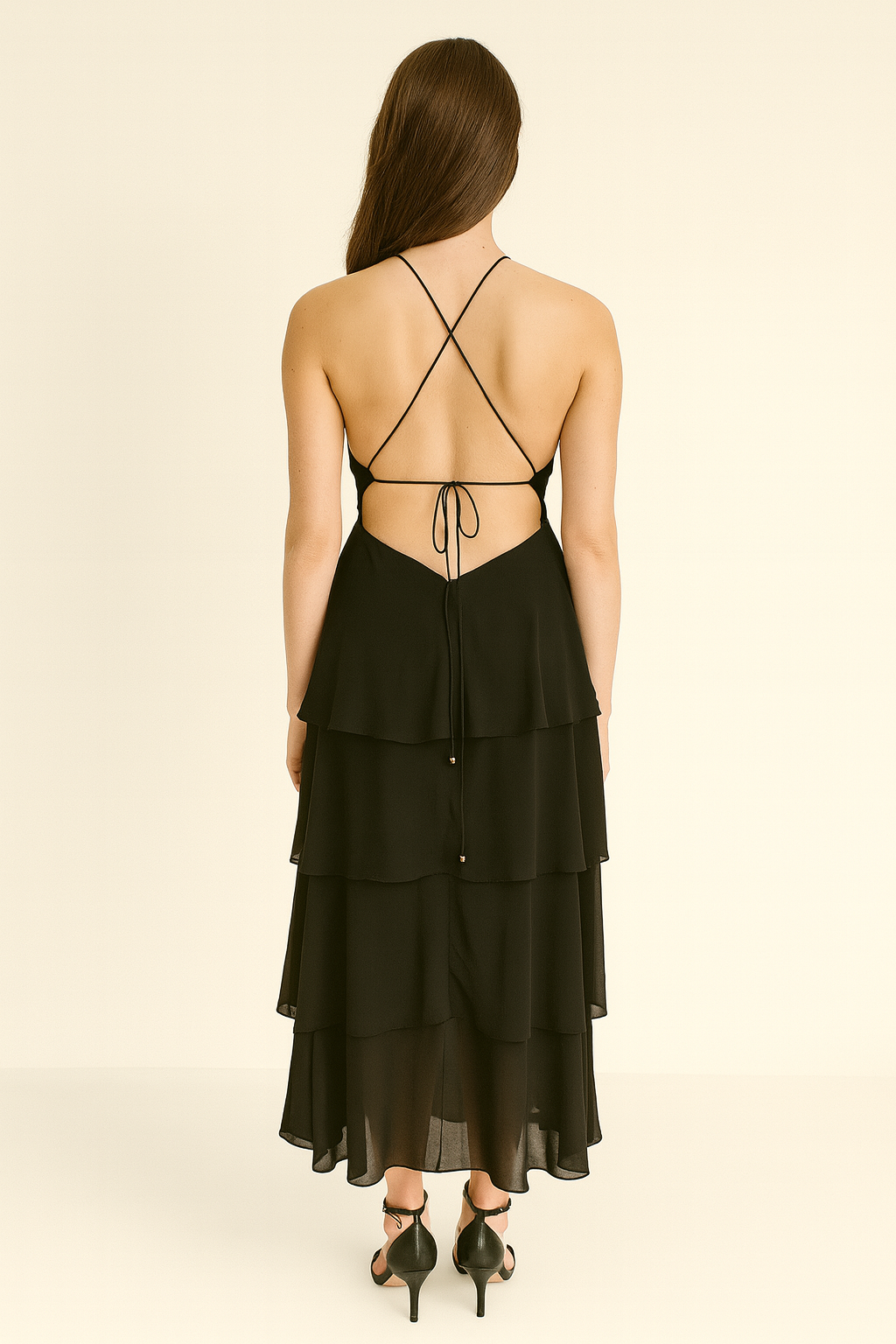 Black tiered dress with open back on a beige background