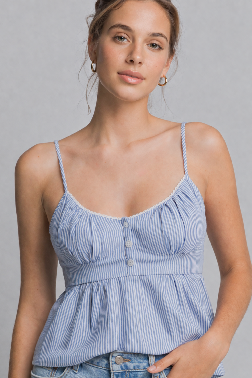 Woman wearing a blue striped top against a gray background