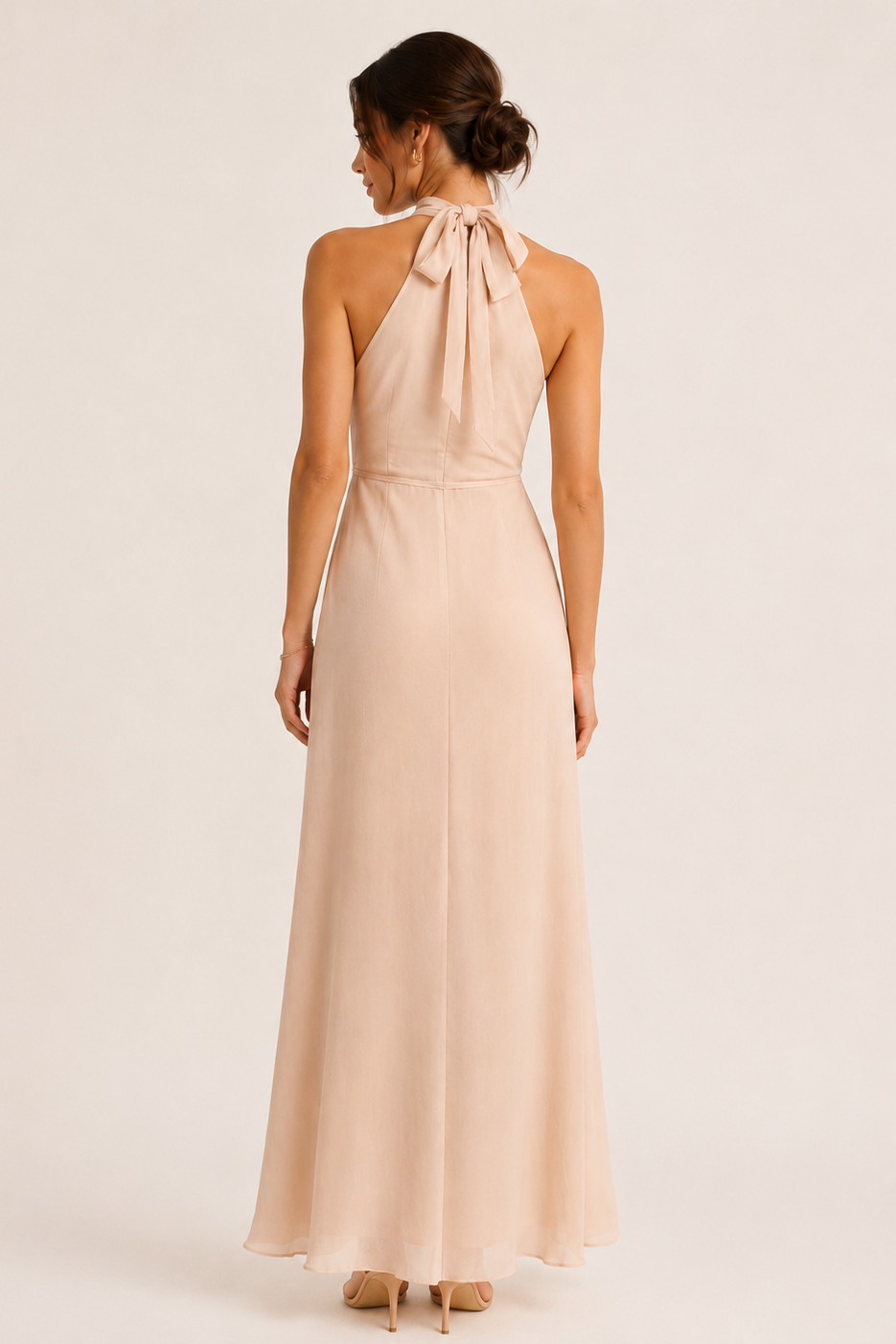 Woman wearing a beige halter neck dress on a white background