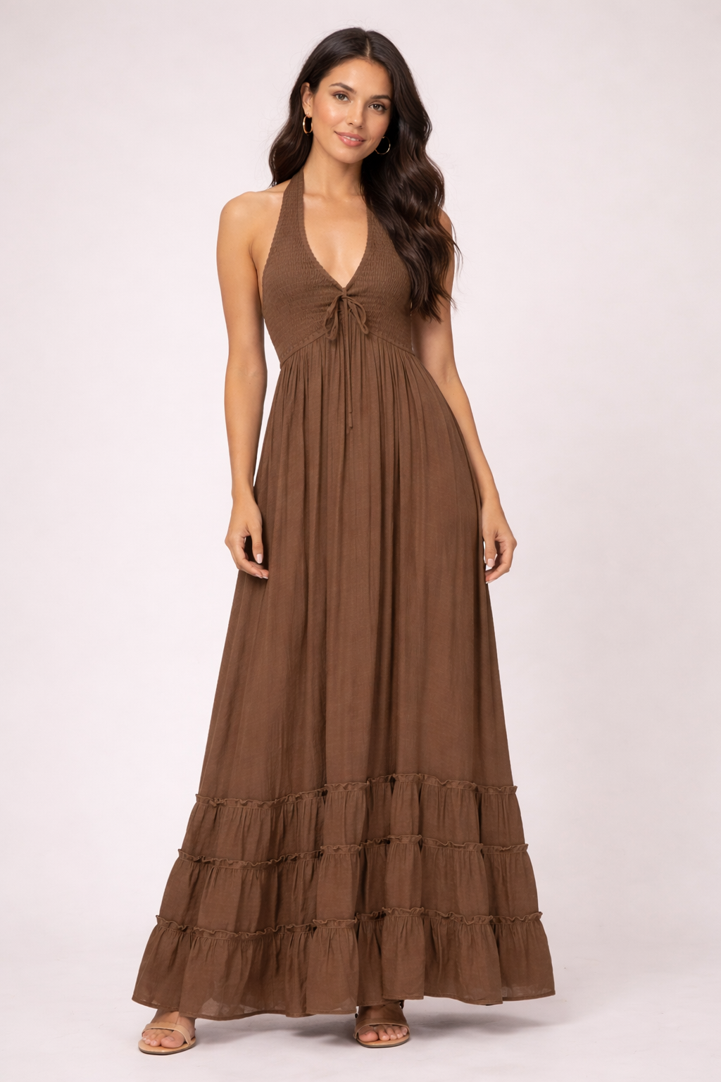 Woman wearing a brown halter neck dress on a white background