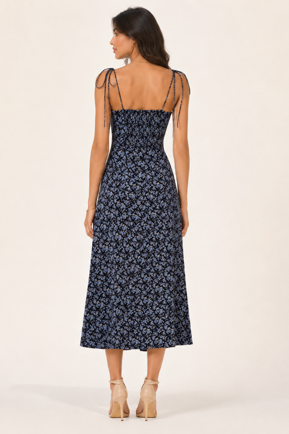 Woman wearing a navy floral dress on a white background