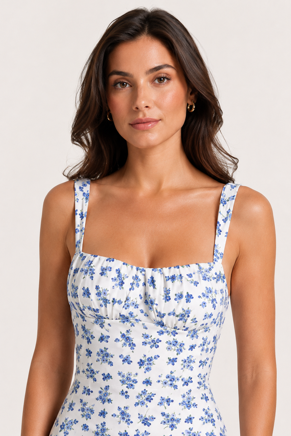 Woman wearing a blue floral dress against a plain background
