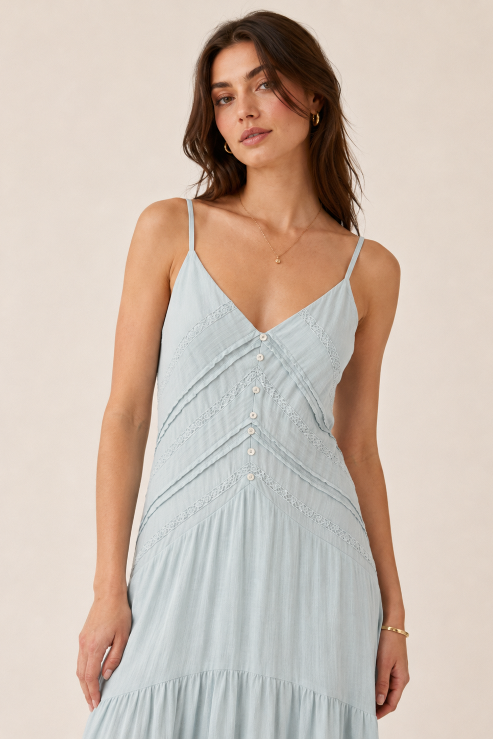 Woman wearing a light blue dress against a beige background