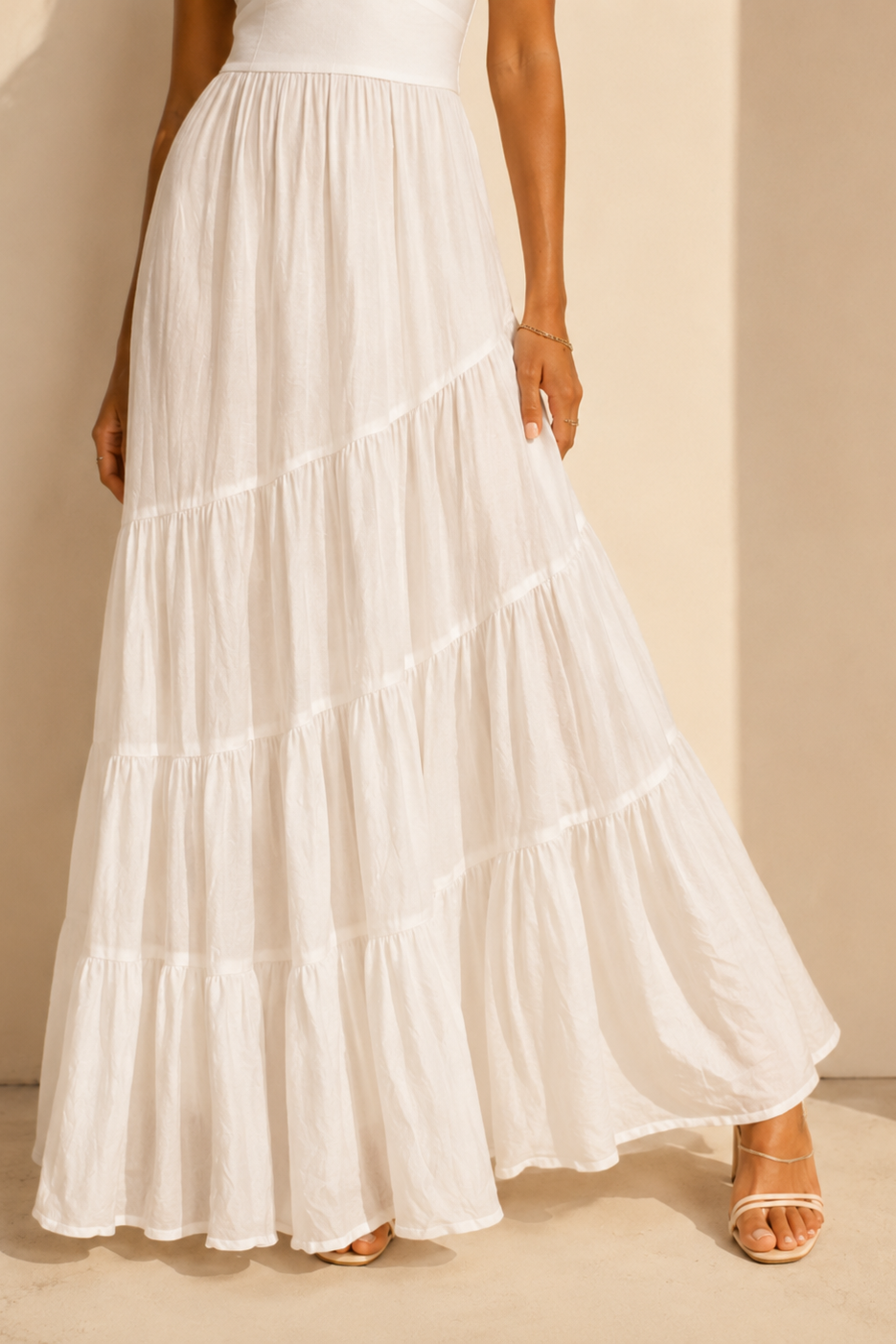 White tiered dress on a person against a beige background