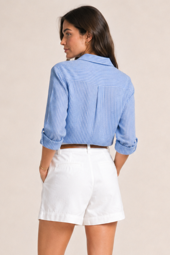 Woman wearing a blue checkered shirt and white shorts on a beige background