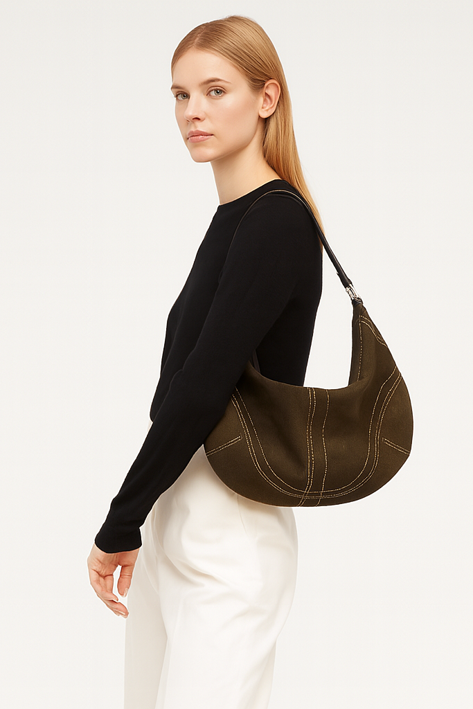 Woman carrying a brown leather handbag on a plain background