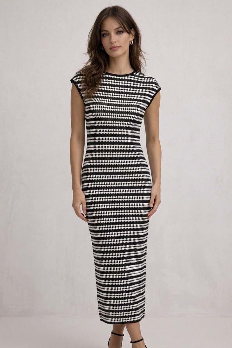 Woman wearing a black and white patterned dress on a plain background