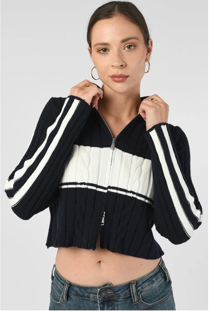 Woman wearing a navy and white striped sweater with a plain background