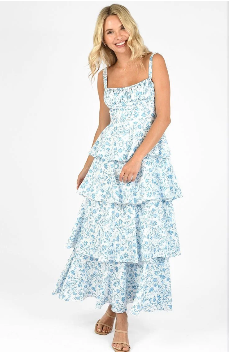 Woman wearing a tiered blue floral maxi dress with shoulder straps 